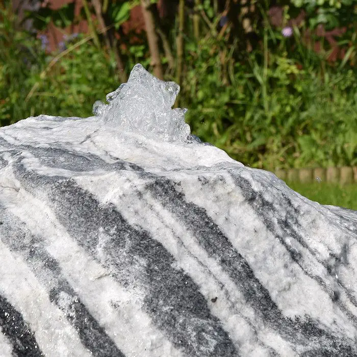 Wachauer marble boulder with a gentle water film over its natural surface